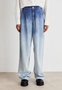 Ανοιχτού μπλε τζιν παντελόνι με φαρδιά γραμμή και κλιμακωτή απόχρωση, με κούμπωμα κουμπιού, εμπρόσθιες τσέπες και χαλαρή εφαρμογή. Ορατή υφή στην επιφάνεια.