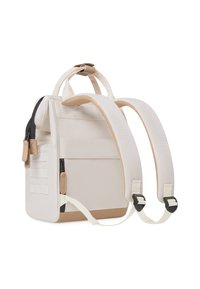 Sac à dos beige clair en tissu durable, équipé de deux bretelles rembourrées, d'une poignée supérieure et de compartiments zippés pour le stockage.