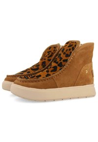 Botas de tobillo de ante marrón con una parte superior de estampado de leopardo, detalles de costura y una suela gruesa de color crema.