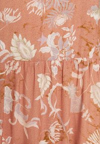 Floral fabric in pink and lavender tones, featuring a textured background with a ruffle detail at the bottom and intricate botanical patterns.