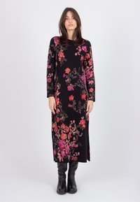 Black long-sleeve dress featuring vibrant floral patterns in pink and red. Below-knee length with a side slit and ribbed cuffs.