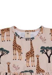 Helles beiges Kleid mit einem Giraffenmuster, dunklen grünen Bäumen und korallenfarbenen Akzenten. Runde Halslinie mit weichem Stoffgefühl.