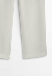 Pantalon droit beige clair avec ourlet retroussé, montré de la mi-cuisse à la cheville sur un fond uni.
