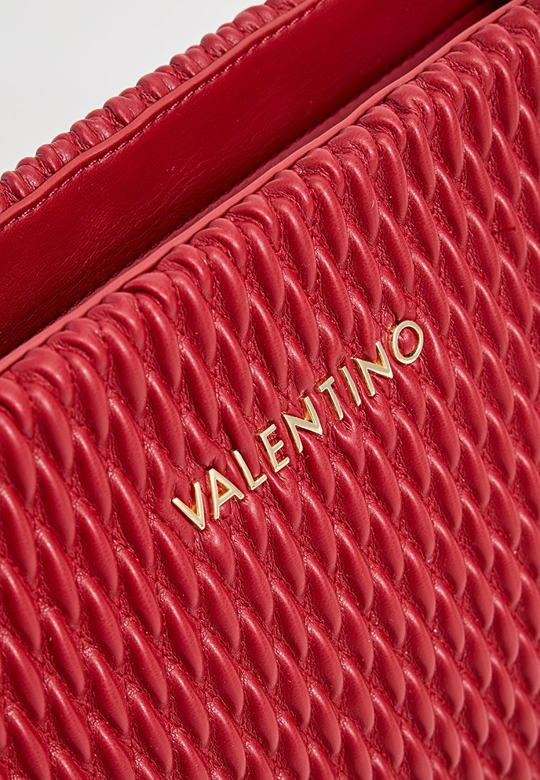 Rote Lederhandtasche mit geflochtenem Textur, ausgestattet mit einem goldenen "Valentino"-Logo. Das Design hat ein glattes Innenleben und eine definierte Nahtführung.