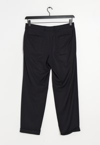 Pantalon noir en tissu léger, avec un design soigné, des ourlets à revers, des poches arrière et une texture lisse.