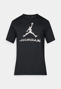 Sort bomulds t-shirt med korte ærmer, prydet med et stort hvidt Jordan-logo grafik på forsiden og fede bogstaver.