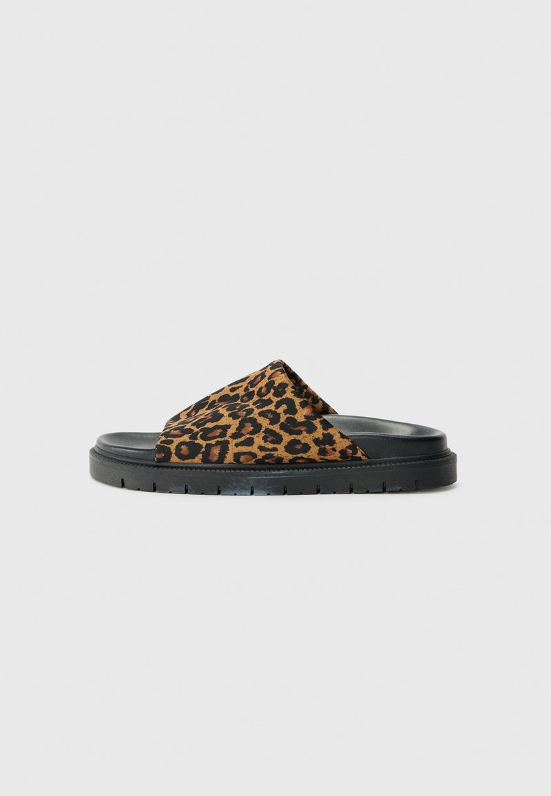 Leopard print slide sandal features a soft upper material, a black rubber sole, a cross-strap design, and textured detailing.