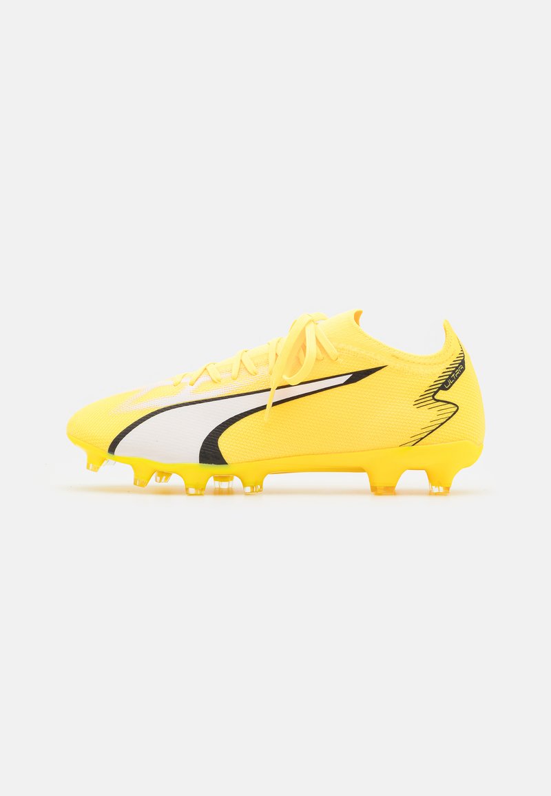 Botín de fútbol amarillo con una parte superior de malla texturizada, acentos en blanco y negro, y seis tacos amarillos en la suela para tracción.