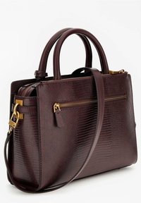 Burgundin värinen tekstuuri nahkalaukku, jossa on kaksinkertaiset kahvat, säädettävä olkahihna ja kullanväriset yksityiskohdat. Edessä on vetoketjullinen tasku.