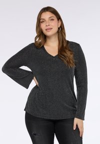 Czarna bluzka z długim rękawem i dekoltem w serek, zdobiona pionowymi srebrnymi paskami, marszczeniem po bokach i rozszerzanymi mankietami. Miękka tkanina o subtelnym połysku.