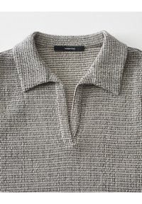 Pullover a collo con texture in un motivo bianco e nero, con scollo a V e un'etichetta con la scritta "un giorno". Tessuto misto cotone.