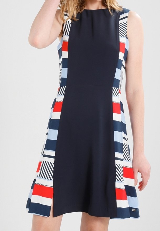 Vestido con un top sólido en marino y un patrón a rayas en rojo, azul y negro en los laterales, diseño sin mangas y dobladillo acampanado.