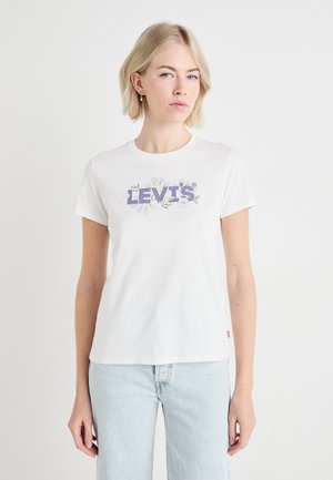 T-shirt bianco in cotone con un logo Levi's lilla circondato da grafiche floreali. Maniche corte e scollatura a girocollo classica.