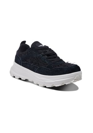 Czarny, teksturowany niskoprofilowy sneaker z grubą białą podeszwą i czarnymi sznurowadłami, pokazany pod kątem na białym tle.