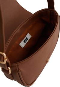 Brun faux läder handväska med ett gyllene spänne. Insidan har en slät orange foder och en vit etikett med varumärket.