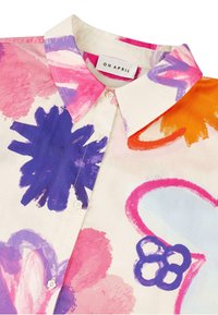 Chemise à boutons avec des motifs floraux vifs en rose, violet et orange, fabriquée en tissu léger et dotée d'un col pointu.
