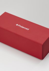 Red rectangular box made of smooth, matte material; features white "Polaroid" logo centered on the top surface.