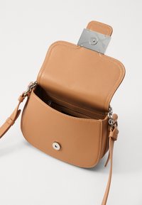 Taschenhandtasche aus braunem Leder mit glatter Oberfläche, silbernem Beschlag, einem Schnappverschluss und einem einstellbaren Riemen. Verfügt über Innenfächer.