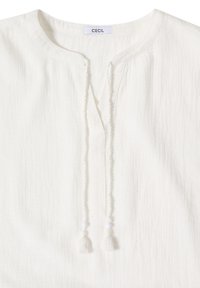 Blouse blanche texturée avec encolure ronde et cordons à pompons, étiquetée "CECIL" à l'intérieur du col.