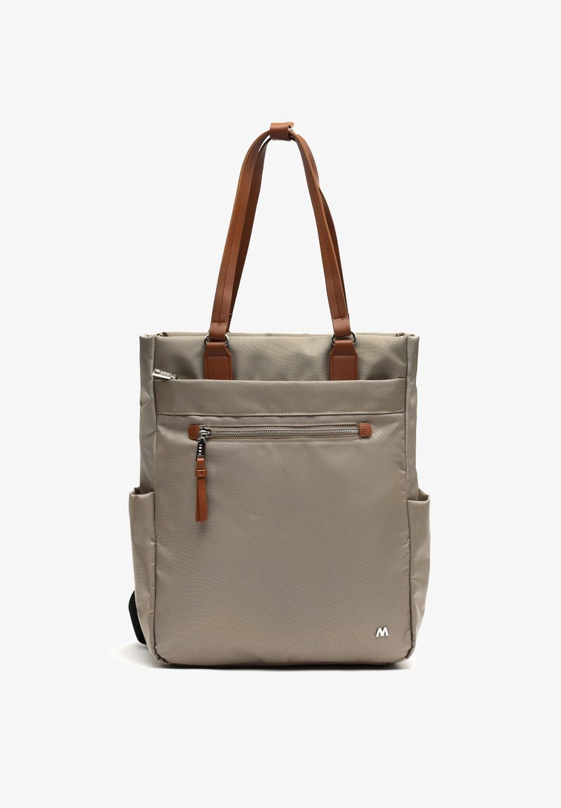 Smėlinė didelė rankinė, pagaminta iš tvirto audinio, su rudomis odinėmis rankenomis, priekyje esančia užtrauktuko kišene, šoninėmis kišenėmis ir minimalistiniu logotipu apačioje.