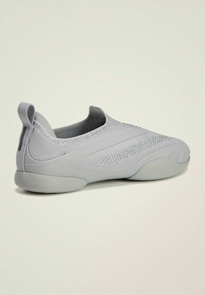 Baskets grises claires à enfiler avec dessus en tissu tricoté, semelle flexible, et languette au talon, présentées de côté sur un fond neutre.