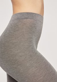 Grijze leggings van een gladde, rekbare stof met een aansluitend ontwerp, taps toelopende pijpen en een elastische tailleband voor comfort.
