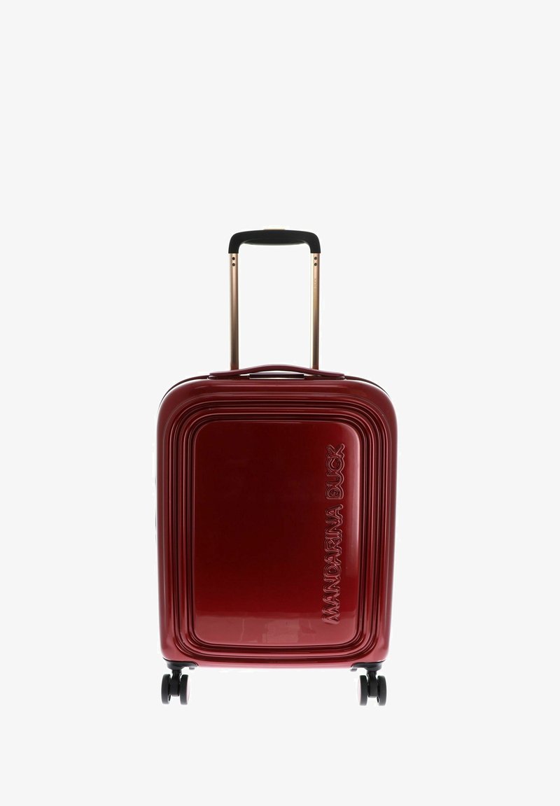 Czerwona twarda walizka o liniowym wzornictwie, z złotą, wysuwaną rączką i czterema czarnymi kółkami. Logo wytłoczone na przedniej stronie.