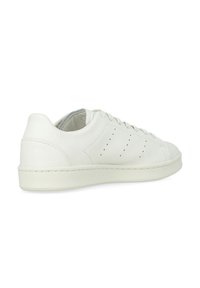 Sneaker bianco in pelle con una texture liscia, punta arrotondata, lacci piatti, dettagli a perforazione sui lati e suola in gomma.