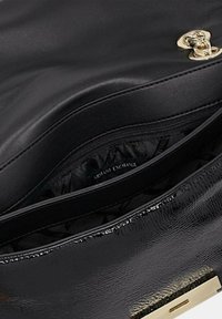 Borsa a tracolla in pelle nera con finitura lucida, dettagli in metallo dorato e una tasca interna con zip foderata con logo.