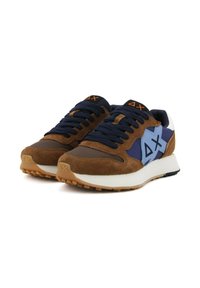 Sneaker in suede marrone e tessuto blu con accenti blu, branding nero e arancione, robusto intersuola bianca e suola in gomma texturizzata.