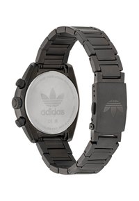 Fekete rozsdamentes acél óra láncos pánttal, kerek tok, két nyomógomb és ezüst hátlap, amelyen az Adidas logo található.