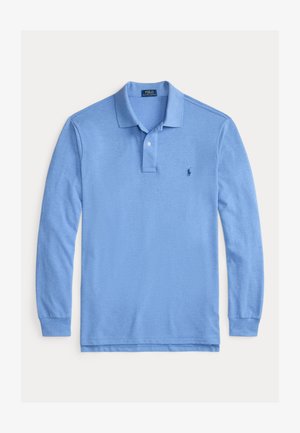 Lyseblå langermet polo skjorte laget av bomull. Har en knappestolpe med to knapper, ribbestrikkede mansjetter, og en liten logo på venstre bryst.