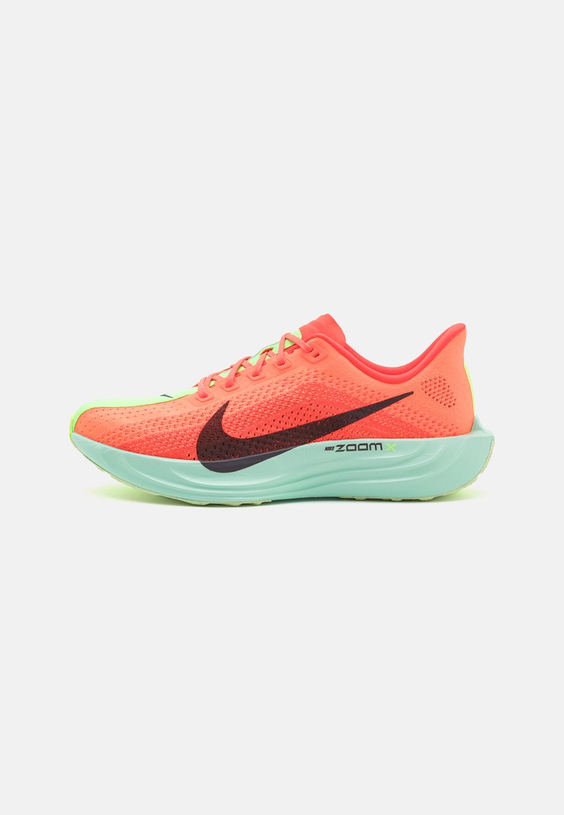 Chaussure de course Nike Zoom X en corail vif avec tige en maille, accents verts et swoosh noir. Caractéristiques : semelle rembourrée pour un confort optimal.