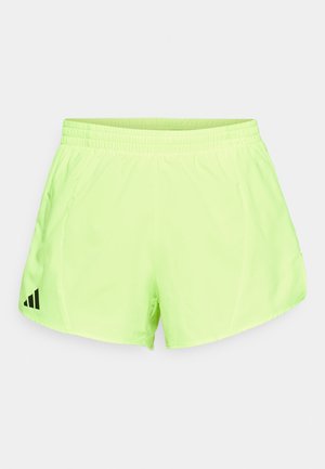 Shorts deportivos de color verde neón, hechos de una tela ligera; cuentan con una cinturilla elástica y un logo de tres franjas negras en el lado izquierdo.