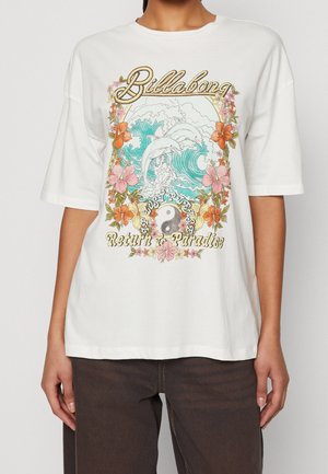 Weißes T-Shirt mit farbigem Aufdruck von zwei Delfinen, die über Ozeanwellen springen, umgeben von Blumen, dem Yin-Yang-Symbol und dem Text "Billabong" und "Return to Paradise".