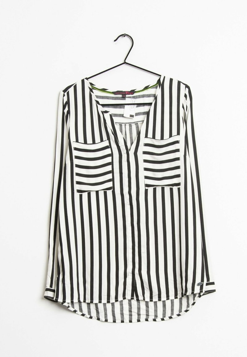 Randig blus med lång ärm i svart och vitt, två bröstfickor, V-ringning och rundad nederkant. Tillverkad av ett slätt tyg med en mjuk textur.