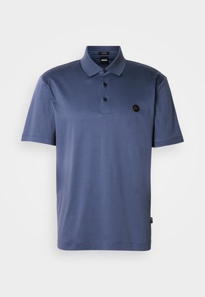 Marineblå poloshirt laget av glatt stoff med tre-knappers knappestolpe, korte ermer og en logopatch på venstre bryst.