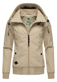 Béžová softshellová bunda s predným zipsom, rebrovanými manžetami a kapucňou na šnúrku. Obsahuje bočné vrecká a štruktúrovanú textíliu.