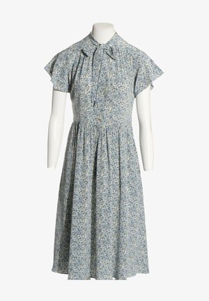 Robe fleurie bleu clair avec manches courtes volantées, col haut et lien noué devant sur un buste de mannequin blanc.