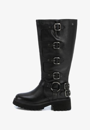 Bota de cuero negro hasta la rodilla con cinco hebillas plateadas, un acento circular cerca del tobillo y una suela de goma texturizada. Diseño de tacón plano.