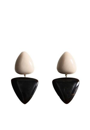 Deux boucles d'oreilles pendantes triangulaires avec une pièce supérieure de couleur crème et une pièce inférieure plus grande et noire brillante, reliées par de petits connecteurs métalliques.