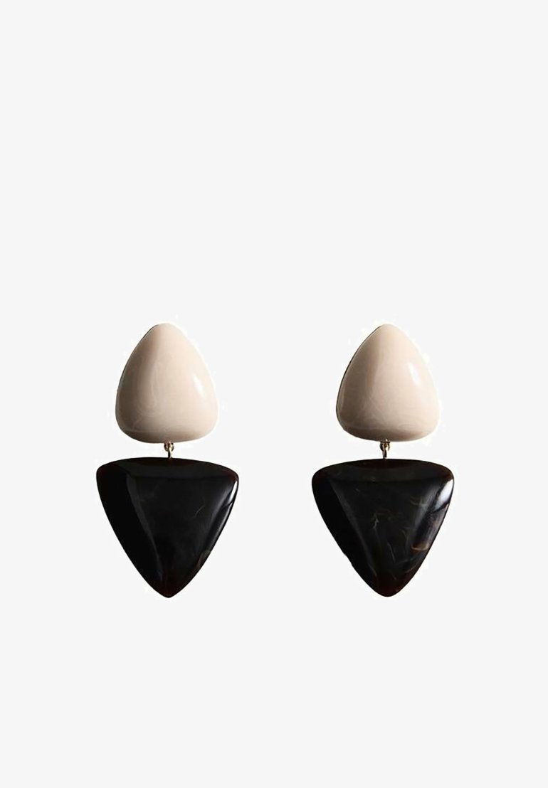 Deux boucles d'oreilles pendantes triangulaires avec une pièce supérieure de couleur crème et une pièce inférieure plus grande et noire brillante, reliées par de petits connecteurs métalliques.