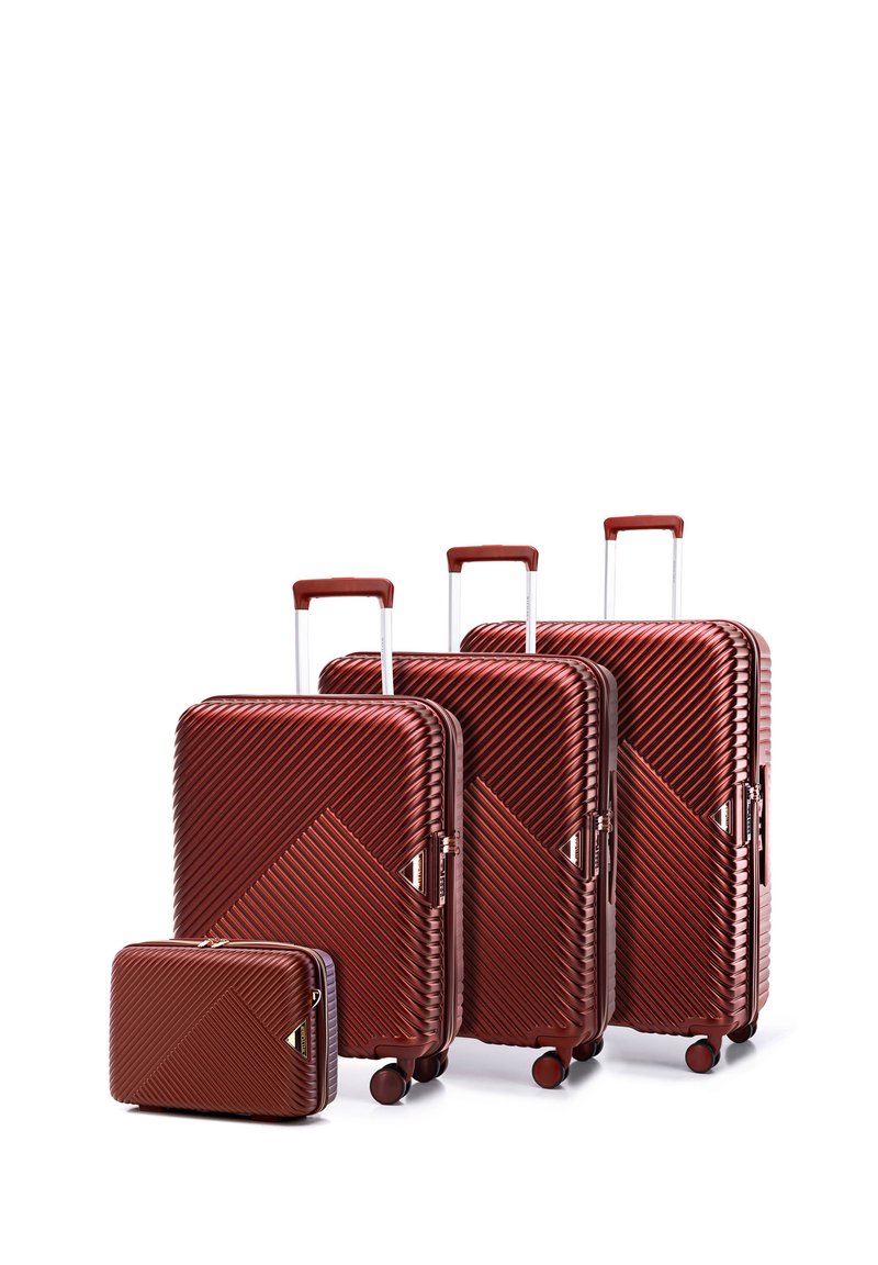 Four red, ribbed suitcases of varying sizes, with diagonal patterns, extendable handles, and wheels for mobility.