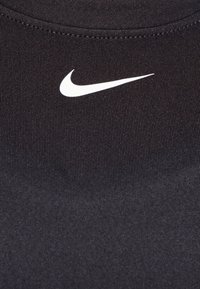 Musta urheilupaita, joka on valmistettu sileästä ja joustavasta kankaasta, ja jossa on valkoinen Nike Swoosh -logo ylärintakohdassa.