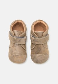 Zapatos para bebé de ante marrón con una textura suave, puntas redondeadas y una correa de Velcro alrededor del tobillo para un ajuste seguro.