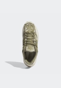 Olivgrön sneakers med en texturerad ovandel, snörningsdesign och krämfärgad sula. Utrustad med silverdetaljer och varumärkeslogotyp på sidorna.
