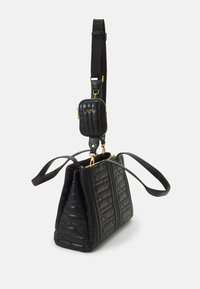 Sac à main en cuir noir matelassé avec quincaillerie dorée, poignées doubles et pochette détachable attachée à la sangle. Forme structurée.