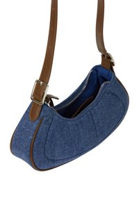 Blå denim crossover taske med en brun læderrem, rund form, lynlås lukning og kontrastfarvet blå indvendig foret.