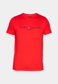 Rød bomulds t-shirt med rund halsudskæring, korte ærmer og marineblå broderet logo tekst: "TOMMY HILFIGER EST. 1985" med en flag accent.