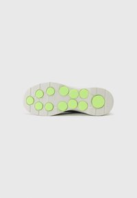 Schuhsohle mit einem strukturierten weißen Grund, die neun erhabene, kreisförmige grüne Akzente in einem Gittermuster aufweist, gestaltet für Grip und Traktion.